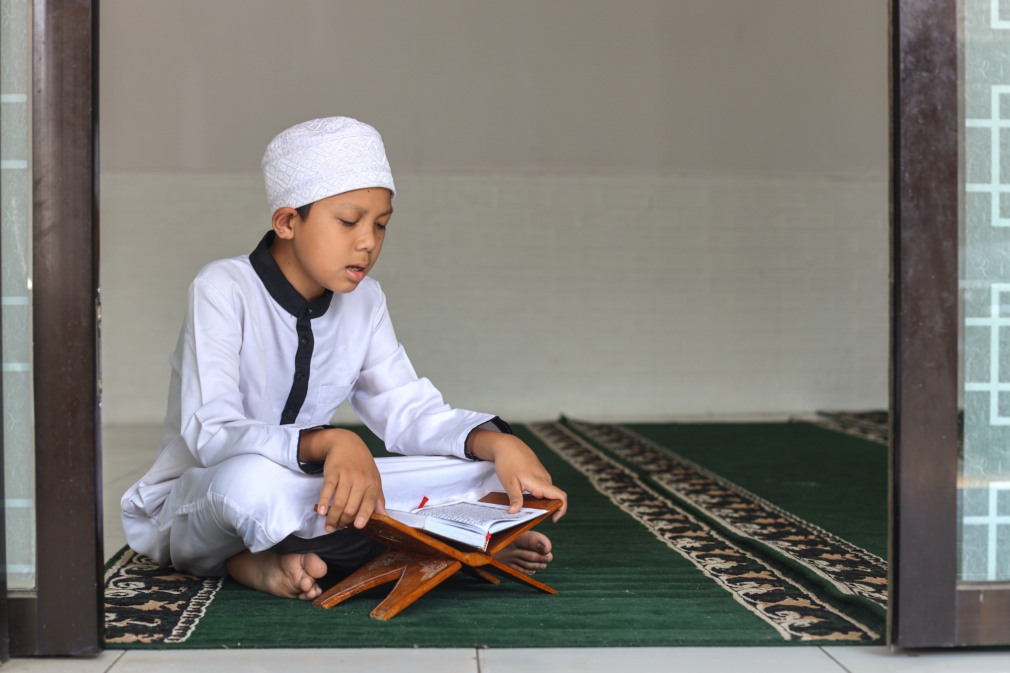 Muslim kid boy reciting koran or Qur'an